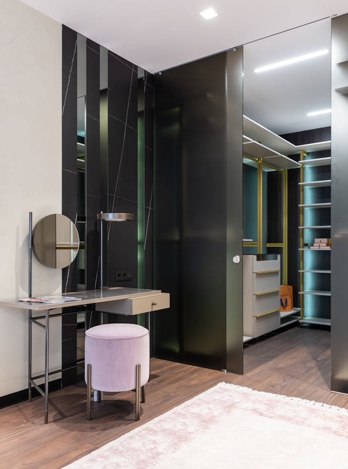 Interior of contemporary apartment with spacious dressing area and vanity table with mirror near padded stool